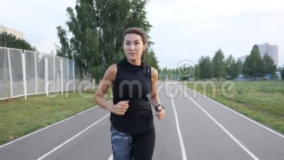 女孩在室外体育场跑步的慢动作视频的预览图