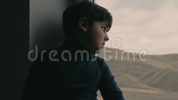 坐在窗边的小男孩视频的预览图