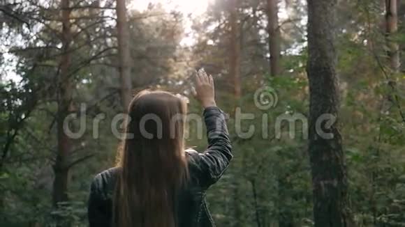 女孩在秋天缓慢地抛着手臂微笑着走进镜头在森林里摆着时尚的姿势视频的预览图