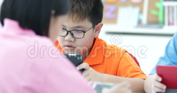 亚洲教师扩大到生物课学生与显微镜视频的预览图