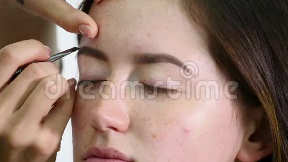 专业化妆师应用眼影模型眼使用特殊的刷子沙龙里的天然化妆美容化妆视频的预览图