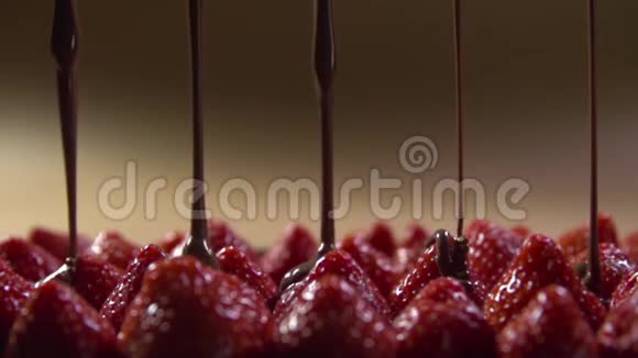 在草莓浆果上倒入一串液体黑巧克力视频的预览图