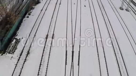 雪中多条电气化铁路轨道和开关空中景观视频的预览图