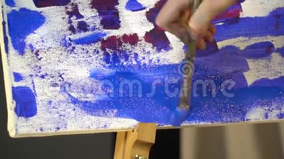 女用手用蓝油漆刷画布视频的预览图