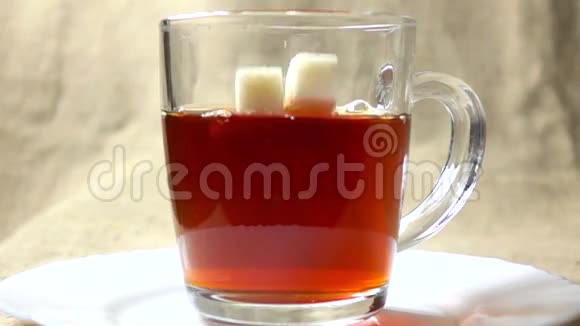 两个糖块落入黑茶杯的超慢动作视频视频的预览图