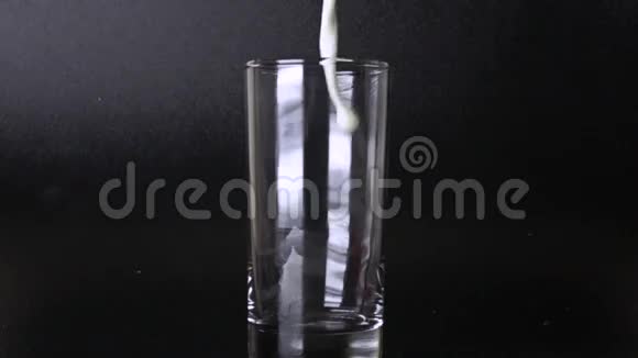 在黑色背景下用玻璃倒入牛奶500fps超慢动作视频视频的预览图