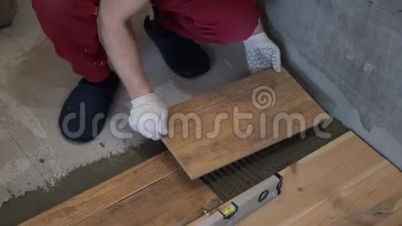 修理和装饰tiler把瓷砖放在公寓的地板上视频的预览图