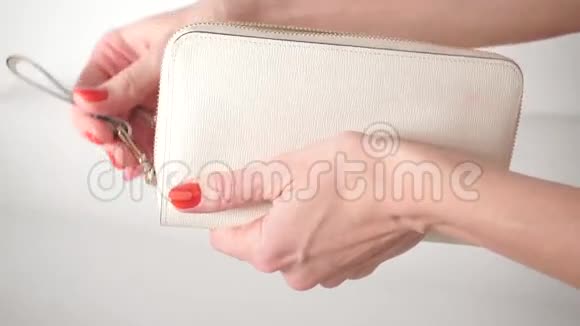 穿着红色指甲油的女孩把她的白色钱包视频的预览图