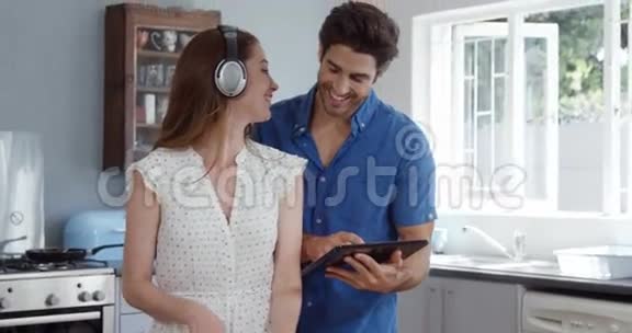 可爱的夫妇在听音乐时使用平板电脑视频的预览图