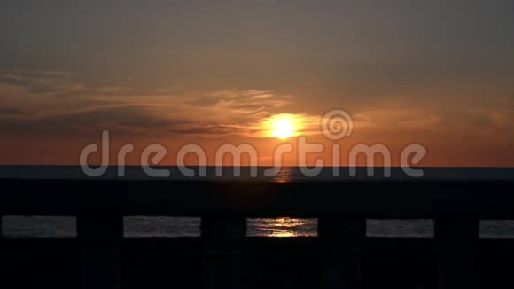 以美丽的日落和平静的大海为背景的海滨栏杆视频的预览图