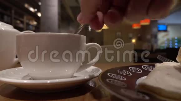 一个人在杯子里搅拌茶一家咖啡馆4K近距离射击视频的预览图
