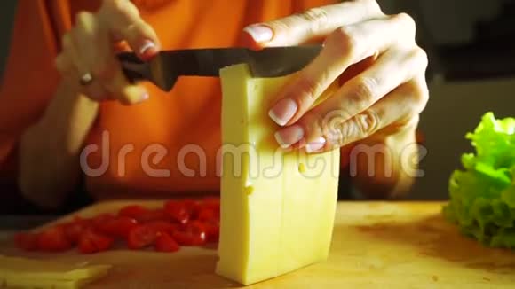 年轻女子在切割板上切奶酪做三明治视频的预览图