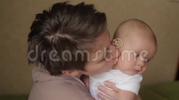 年轻漂亮的妈妈用爱亲吻她的小宝宝视频的预览图