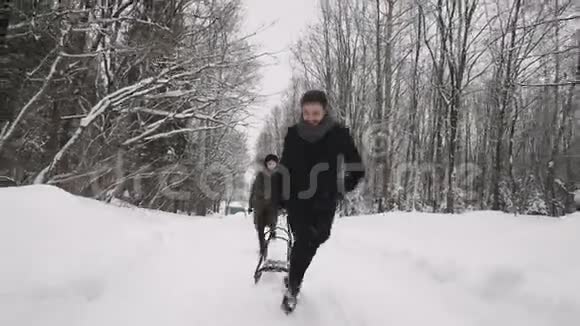 一男一女在森林里的雪地里玩耍冬季乐趣视频的预览图