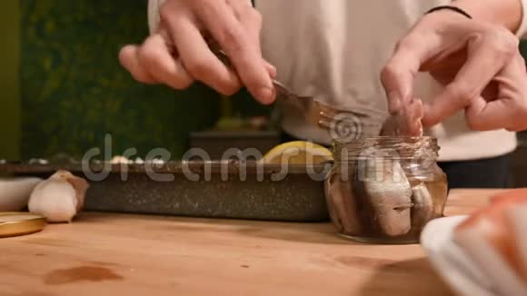 家中厨房里一个女孩的双手合拢用盘子把玻璃罐里的短跑出来健康家园视频的预览图