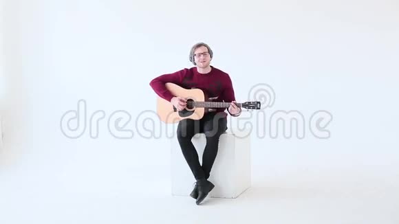 在白音室背景下演奏吉他的人视频的预览图
