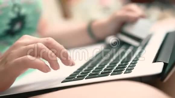女性手拿着信用卡和笔记本电脑视频的预览图