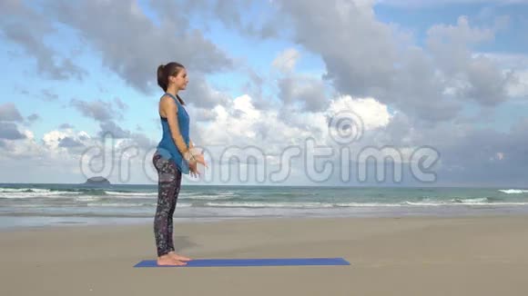 日落时分在海滩上练习瑜伽的女人锻炼冷静与和谐视频的预览图