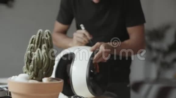 艺术家在老式头盔上画手刻字视频的预览图