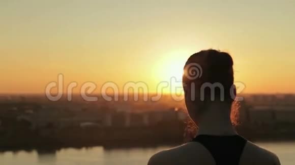 日落时分在公园里练习瑜伽的运动女人莲花泥视频的预览图