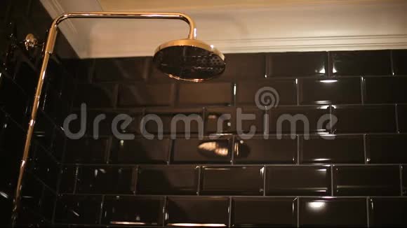 黑色浴室里的金色淋浴器视频的预览图
