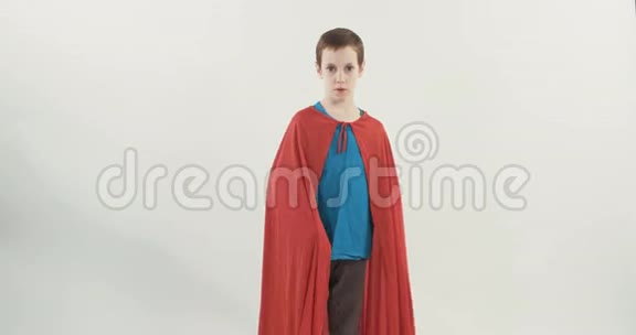 穿着超级英雄斗篷的小男孩站在白色工作室背景上视频的预览图