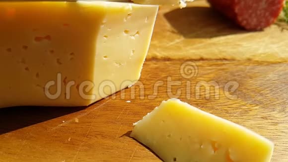 用一把刀在木制的传统慢镜头上切割奶酪视频的预览图