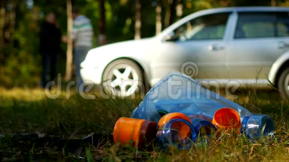 一包带塑料瓶的垃圾躺在大自然上背景中有一辆车人们都是视频的预览图