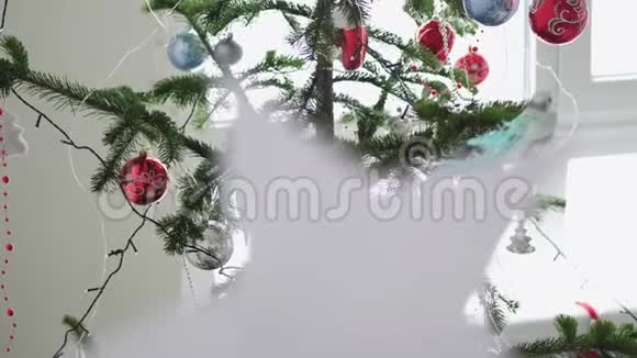 纸上的星星挂在窗户旁边的冷杉树旁边作为圣诞节内部的背景圣诞节的概念慢慢慢慢视频的预览图