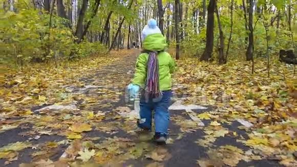 慢动作小男孩在秋天的森林里奔跑视频的预览图