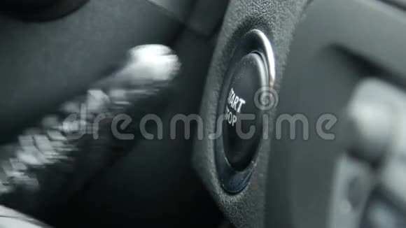 一名女司机按下汽车发动机启停按钮的宏观镜头视频的预览图