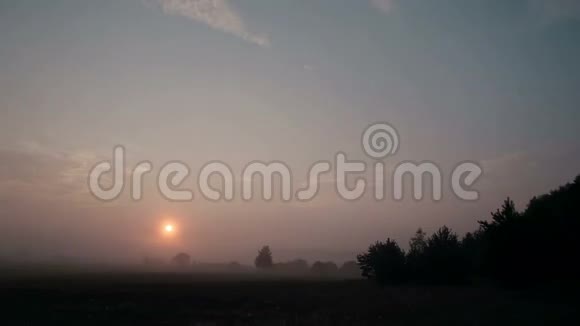 日出时的乡村景色伴随着薄雾慢慢地离开了草地太阳升起时会更亮时间推移视频的预览图