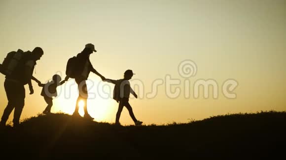 父亲母亲和孩子徒步旅行的剪影婴儿坐在父亲的肩膀上徒步旅行背包旅行者徒步旅行视频的预览图