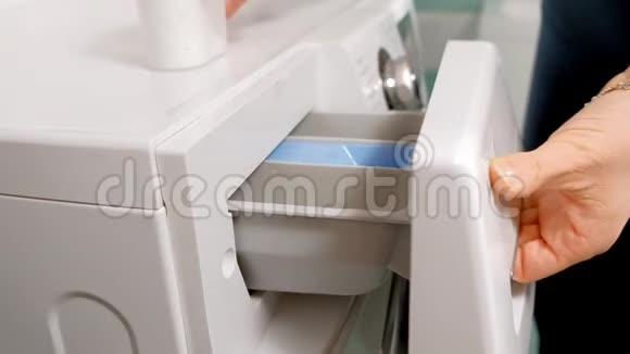 女人在洗衣机和抽屉的隔间里加入洗涤剂视频的预览图