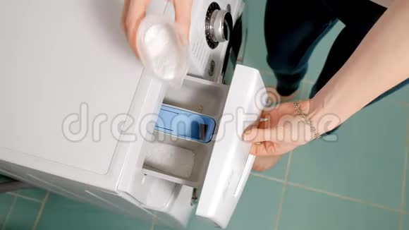 女人在洗衣机和抽屉的隔间里加入洗涤剂视频的预览图