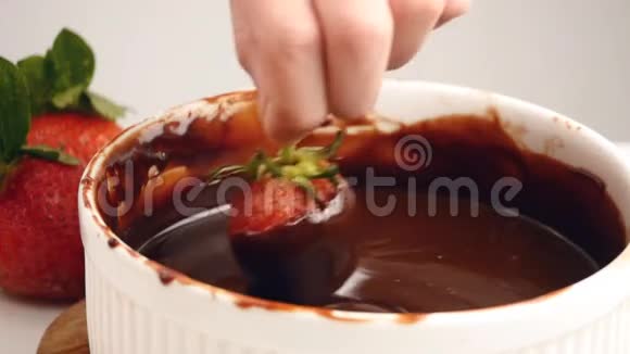 手浸新鲜草莓融化巧克力视频的预览图