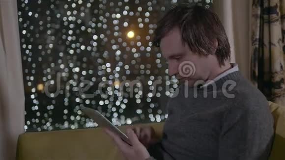 在下班前看一些网上新闻年轻的商人坐在带平板电脑的城市咖啡馆里视频的预览图