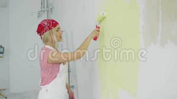 女人用滚筒画墙视频的预览图