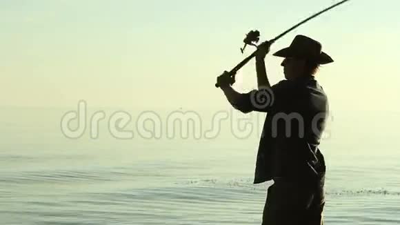 穿着牛仔帽在湖边的渔夫视频的预览图