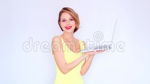 穿着黄色衣服带手提电脑的红发少女视频的预览图