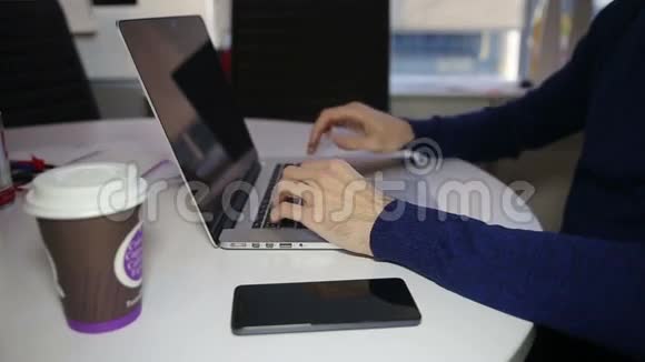 男性手在笔记本电脑键盘上打字视频的预览图