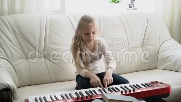 漂亮的女孩弹着MIDI钢琴键视频的预览图