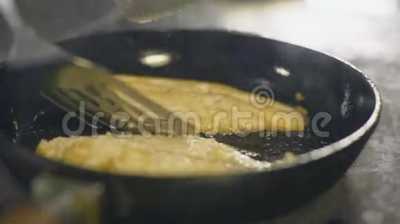 煎锅上油的鱼慢动作视频的预览图