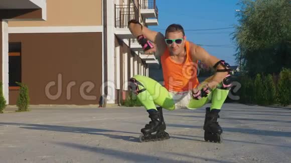 快乐的家伙穿着明亮的衣服在他的溜冰鞋上做姿势慢速视频4k标准镜头视频的预览图