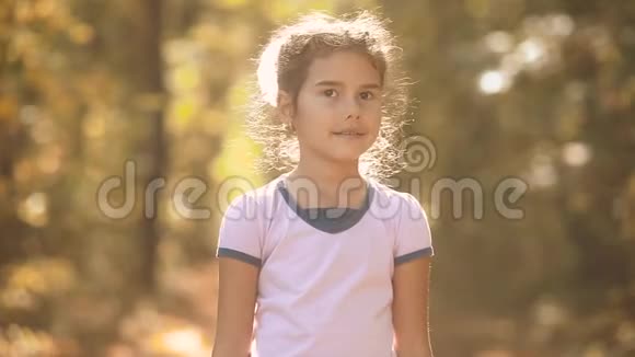 黄色秋林里的小女孩美丽的阳光小女孩在秋天的森林自然景观中散步视频的预览图