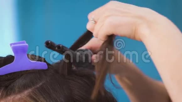 一位发型师在为新娘的婚礼做准备时做卷发视频的预览图