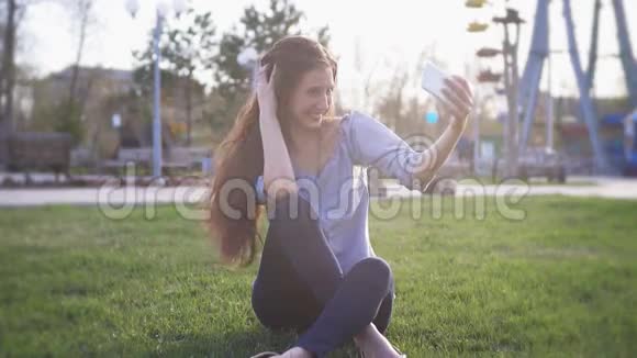 快乐的女孩在阳光明媚的公园里玩得开心笑着自拍视频的预览图