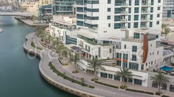 迪拜码头的海滨长廊和运河在时间推移前后有豪华的摩天大楼和游艇阿拉伯联合酋长国视频的预览图