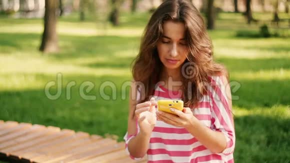年轻的笑脸美女在电话里写短信视频的预览图