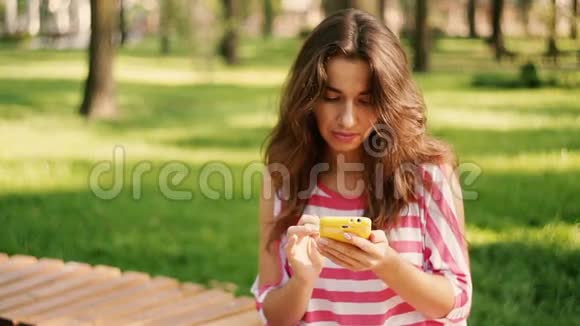年轻的笑脸美女在电话里写短信视频的预览图